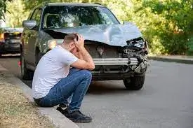 a man sitting next to accidental car